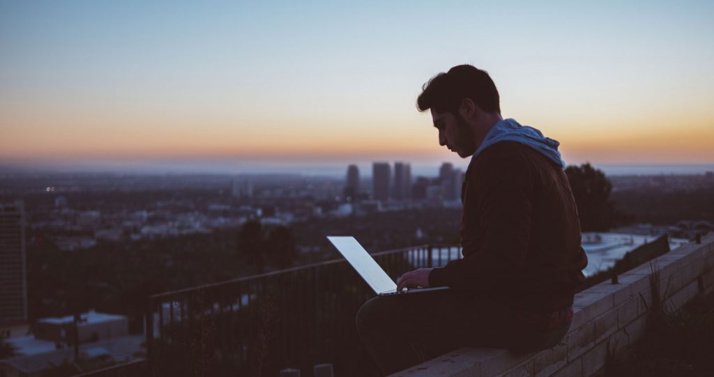 man looking at computer sitting on wall - adcanvas desktop update - NEXD