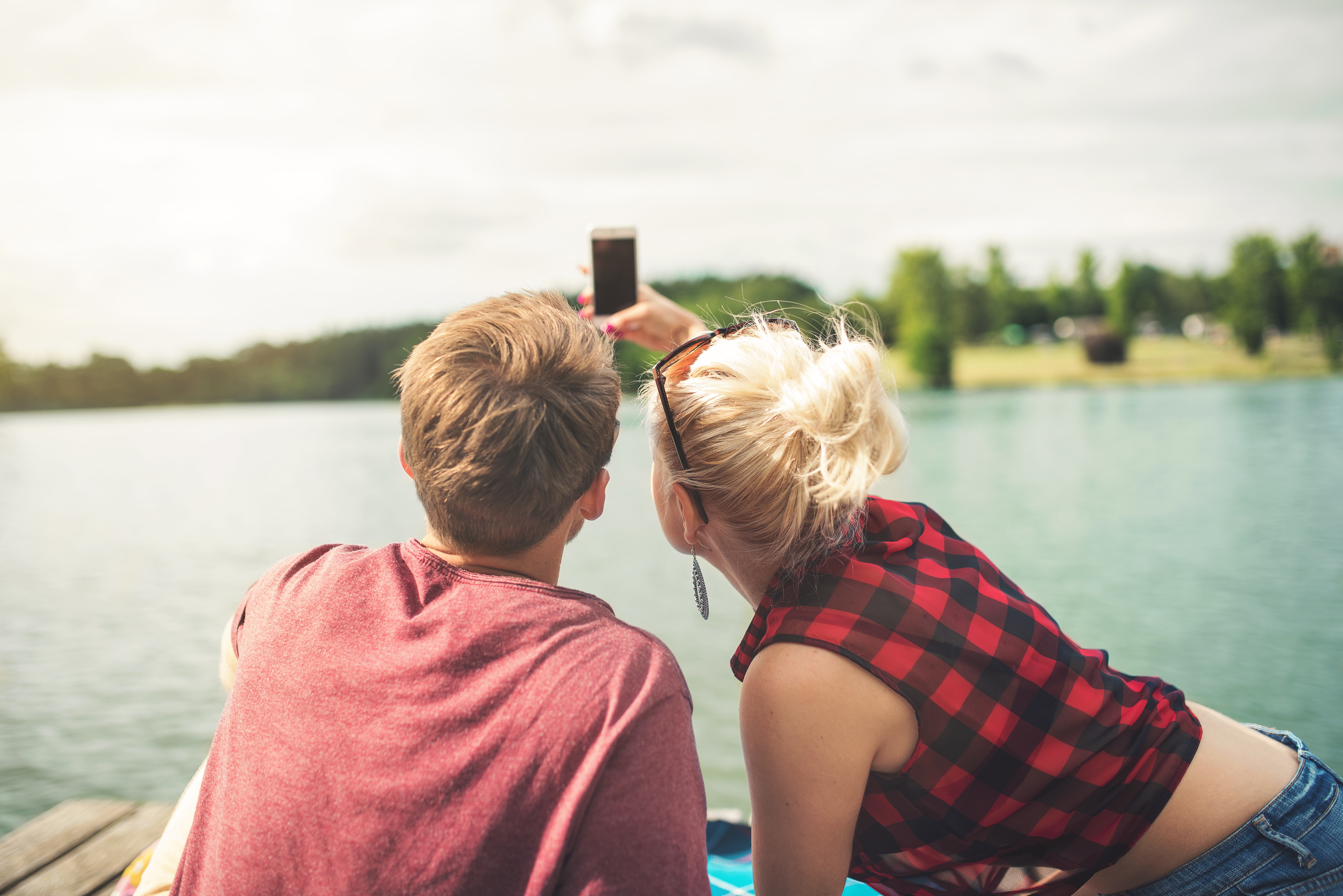 Couple taking a selfie next to a lake