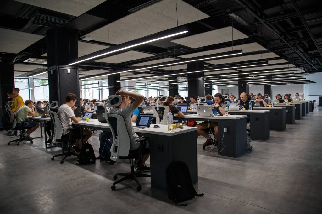 People working on computers at desks in a large office