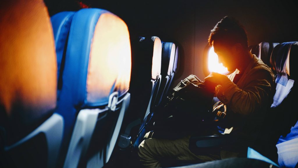 Man sitting on plane as sun comes up