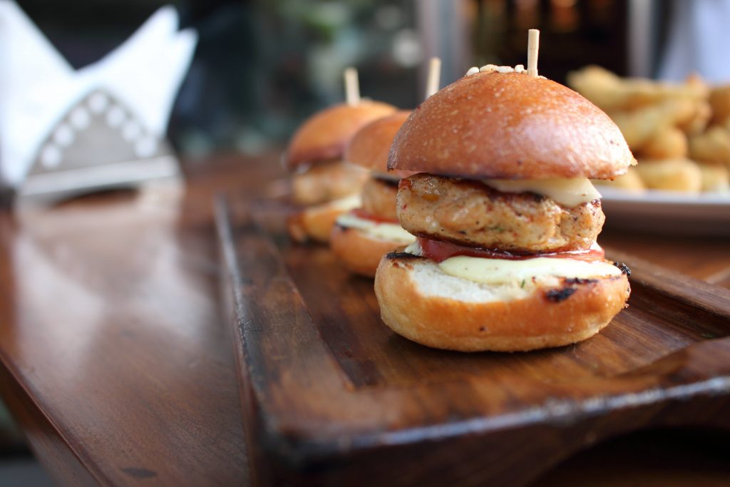 Three chicken sliders on a board