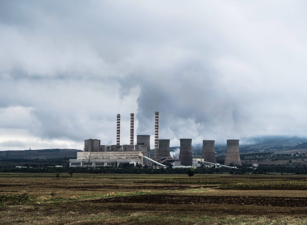 A power station with smoke coming out of its towers